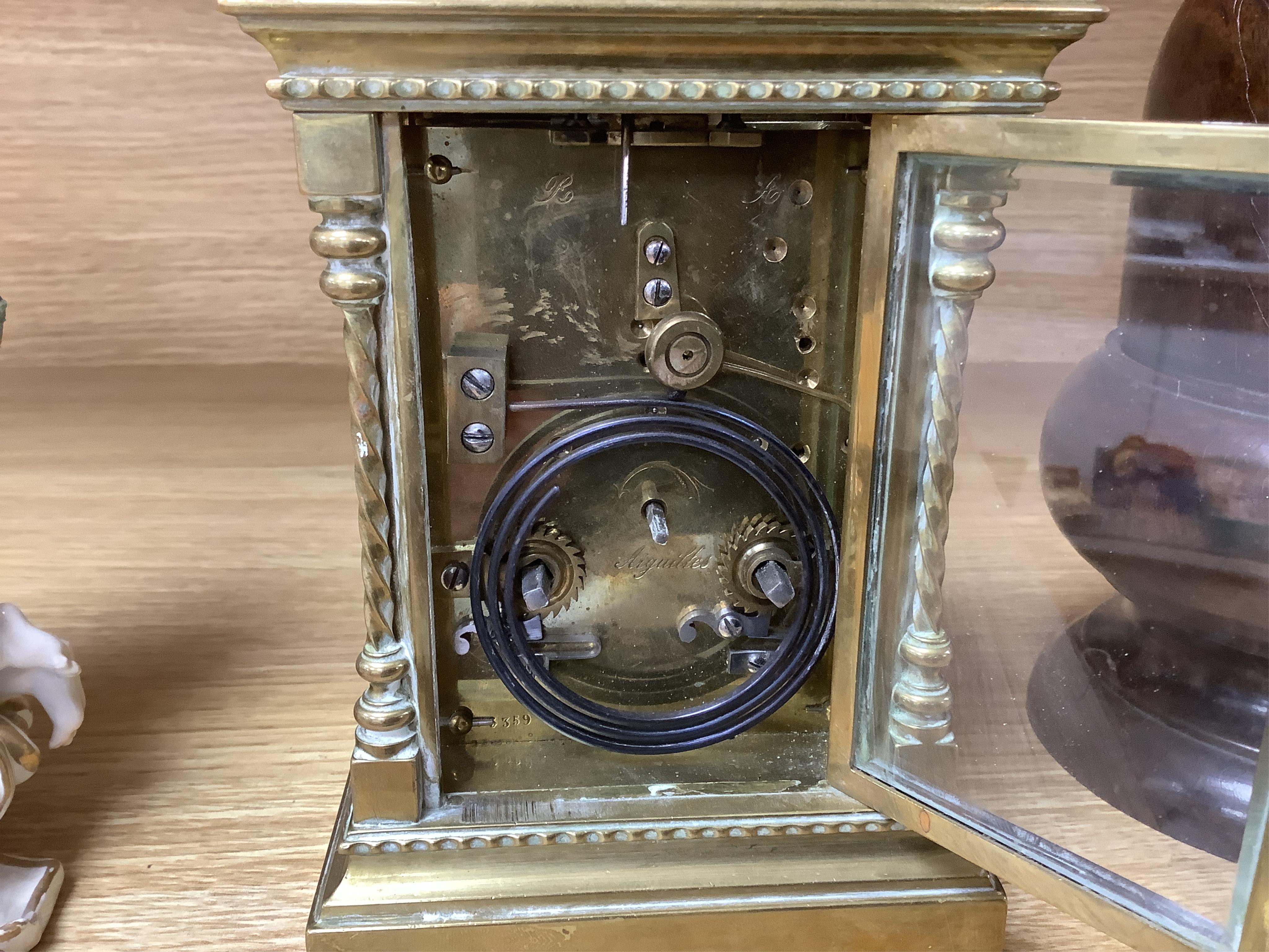 A large brass repeating carriage clock with key and ornate filigree dial, 17cm high (including handle). Condition - good, unchecked if working